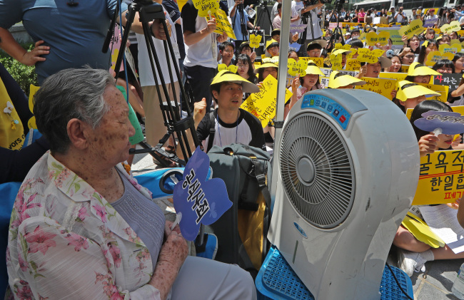 Former comfort woman Kil Won-ok (left) is seen during a protest against a 2015 settlement on Japan's wartime sex slavery in front of the Japanese Embassy in downtown Seoul on Wednesday. (Yonhap)