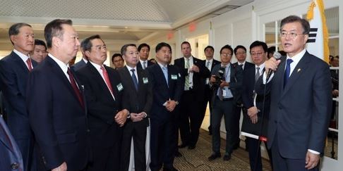 This file photo, taken June 29, 2017, shows President Moon Jae-in (R) holding a brief meeting with South Korean businesspeople in Washington during his official visit to the US capital for a summit with US President Donald Trump. (Yonhap)