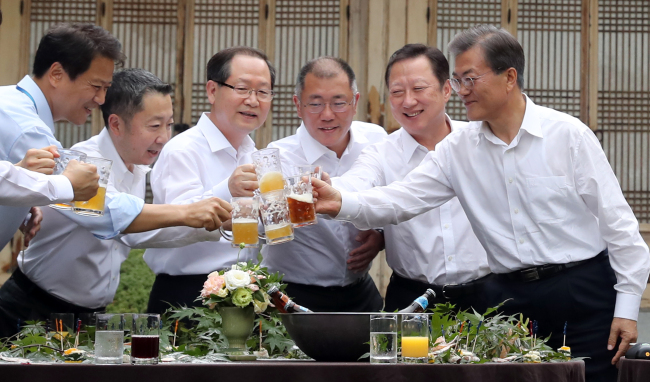 President Moon Jae-in enjoys a beer with Korea’s corporate tycoons in the gardens of the Blue House in Seoul, Thursday. From left: Moon, Korea Chamber of Commerce and Industry Chairman Park Yong-maan, Vice President of Hyundai Motor Chung Eui-sun, Hanwha Group Vice Chairman Keum Chun-soo, Doosan Group Chairman Park Jeong-won and Presidential Chief of Staff Im Jong-seok. (Yonhap)
