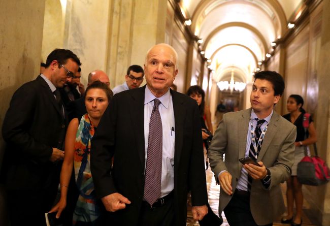 Sen. John McCain (center) leaves the the Senate chamber at the US Capitol in Washington after voting on a health care bill on Friday. (AFP-Yonhap)
