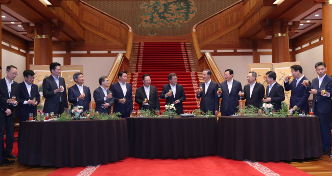 President Moon Jae-in and government officials meet with business leaders at Cheong Wa Dae on Friday. Yonhap