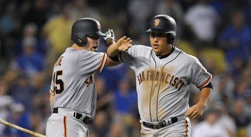 In this Associated Press photo taken on July 28, 2017, Hwang Jae-gyun of the San Francisco Giants (R) is congratulated by Matt Moore after scoring a run against the Los Angeles Dodgers in the teams' Major League Baseball game at Dodger Stadium in Los Angeles. (Yonhap)