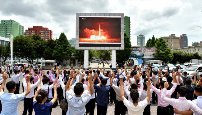 This image published by North Korea's Rodong Sinmun on Sunday show citizens celebrating Friday's test of the Hwasong-14 intercontinental ballistic missile in front of Pyongyang Station. (Yonhap)