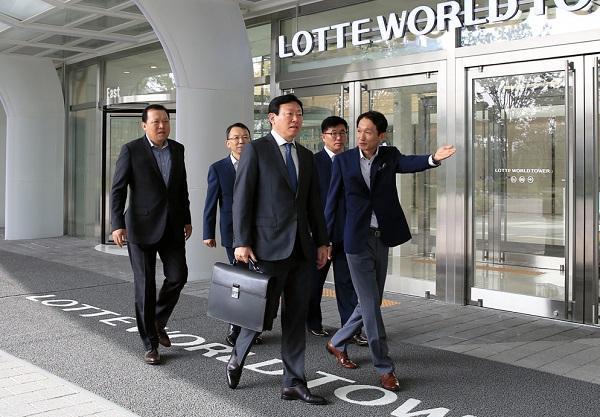 신동빈 롯데그룹 회장(사진 가운데)이 임직원들의 안내를 받으며 월드타워에 출근하고 있는 모습.