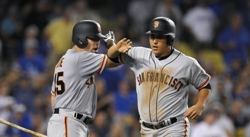 In this Associated Press photo taken on July 28, 2017, Hwang Jae-gyun of the San Francisco Giants (R) is congratulated by Matt Moore after scoring a run against the Los Angeles Dodgers in the teams' Major League Baseball game at Dodger Stadium in Los Angeles. (Yonhap)