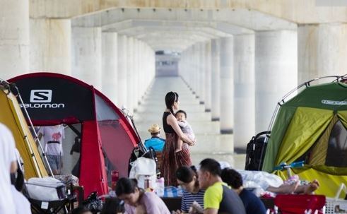 People rest along the Han River flowing through the center of Seoul on Aug. 1, 2017, as sweltering heat hits South Korea. (Yonhap)