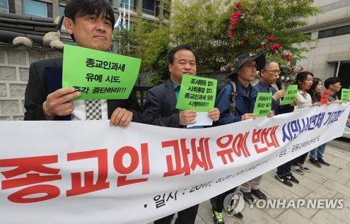 In this file photo, a group of activists from the Korea Taxpayers' Association hold a protest rally in front of the State Affairs Planning Advisory Committee building in central Seoul on May 31, 2017, demanding that clerical workers pay taxes like all waged workers. (Yonhap)