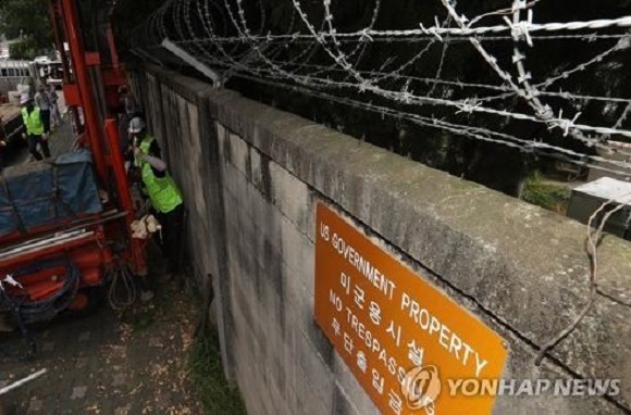 Officials from the Seoul Metropolitan Government and survey experts extract soil and water from an fenced-off area just outside the US military base in Yongsan, on Aug. 9, 2017, as part of its own analysis on possible chemical contamination. (Yonhap)