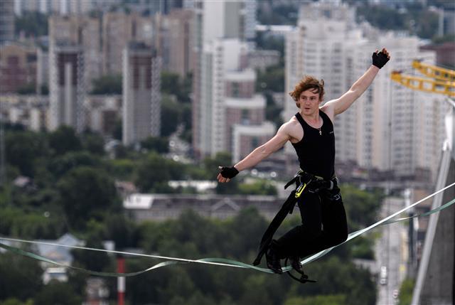 <YONHAP PHOTO-0418> YEKATERINBURG, RUSSIA - AUGUST 9, 2017: Slackliner Maxim Kagin walks on a rope stretched between two skyscrapers of the Champion Park residential complex at the height of 126 m (37th floor). Donat Sorokin/TASS/2017-08-10 02:08:41/ <저작권자 ⓒ 1980-2017 ㈜연합뉴스. 무단 전재 재배포 금지.>