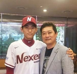 In this file photo provided by the Nexen Heroes baseball club on July 5, 2016, Lee Jung-hoo (L) poses with his father Lee Jong-beom, former Korea Baseball Organization MVP, after being selected in the annual draft. (Yonhap)
