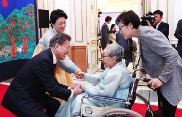 President Moon Jae-in (L) greets a former sex slave for the Japanese military before the start of a meeting with some 250 national heroes and independence fighters at the presidential office Cheong Wa Dae on Aug. 14, 2017. (Yonhap)