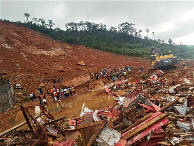 <YONHAP PHOTO-0162> (170815) -- FREETOWN, Aug. 15, 2017 (Xinhua) -- Rescuers and a mechanical digger work at the site of mudslide during a rescue operation in Freetown, Sierra Leone, on Aug. 14, 2017. Government of Sierra Leone is expected on Tuesday to undertake the burial of the majority of corpses of victims in the devastating mudslide which had claimed nearly 300 lives, sources close to the government told Xinhua. (Xinhua/Wang Bo) (zf)/2017-08-16 00:37:25/ <저작권자 ⓒ 1980-2017 ㈜연합뉴스. 무단 전재 재배포 금지.>