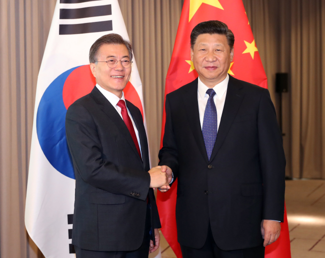 President Moon Jae-in (left) and his Chinese counterpart Xi Jinping shake hands before their summit in Berlin on July 6. (Yonhap)