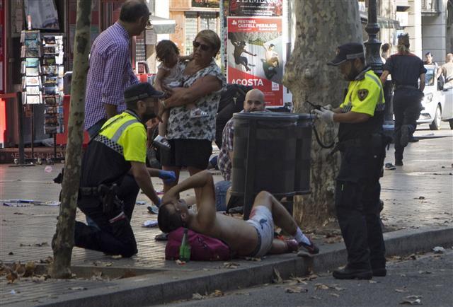 <YONHAP PHOTO-0236> epa06148659 Mossos d'Esquadra Police officers attend injured people after a van crashed into pedestrians in Las Ramblas, downtown Barcelona, Spain, 17 August 2017. According to initial reports a van crashed into a crowd in Barcelona's famous Placa Catalunya square at Las Ramblas area injuring several. Local media report the van driver ran away, metro and train stations were closed. The number of people injured and the reasons behind the incident are not yet known. Official sources have not confirmed that the incident is a terrorist attack. EPA/David Armengou FACE PIXELATED BY SOURCE DUE TO LOCAL LAW/2017-08-18 01:28:00/ <저작권자 ⓒ 1980-2017 ㈜연합뉴스. 무단 전재 재배포 금지.>