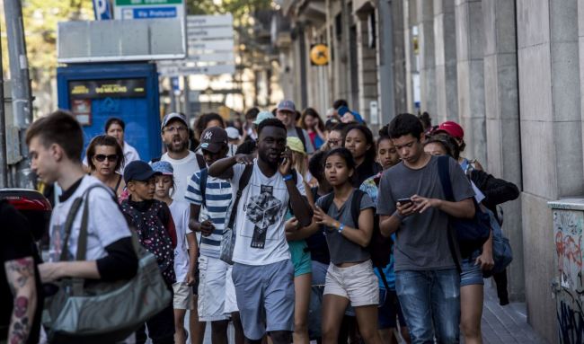 People phone to relatives or friends after a van ploughed into the crowd on the Rambla in Barcelona, Thursday. (AP-Yonhap)