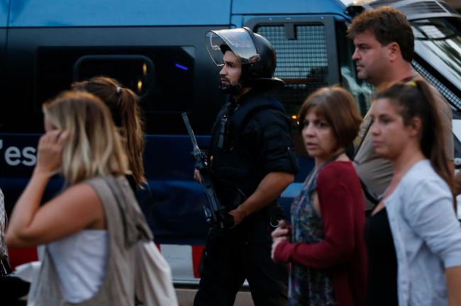 People are escorted by Spanish policemen outside a cordoned off area after a van ploughed into the crowd, killing 13 persons and injuring over 80 on the Rambla in Barcelona on Thursday. (AFP-Yonhap)
