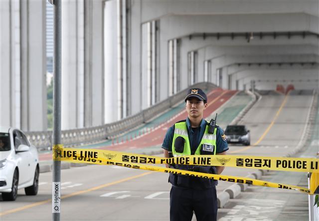 서울 178mm 등 전국 곳곳에 내린 많은 비로 한강 수위가 높아진 21일 오전 서울 잠수교가 만수위에 육박하자 보행자들의 통행이 금지되고 있다. [연합뉴스]