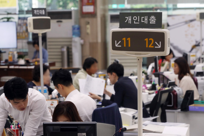 Borrowers talk to consultants about credit-based loans at a bank branch in Seoul on Monday. (Yonhap)