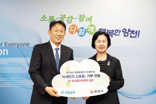 심봉석 이화여자대학교 의무부총장 겸 의료원장(사진 왼쪽)과 김수영 서울특별시 양천구청장(사진 오른쪽)이 미세먼지 신호등 기부 약정식에서 기념 촬영을 하고 있다.