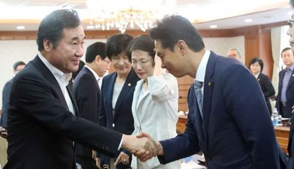 Prime Minister Lee Nak-yon (L) shakes hands with Ryu Young-jin, minister of food and drug safety, during a policy coordination meeing on Aug. 18, 2017. (Yonhap)