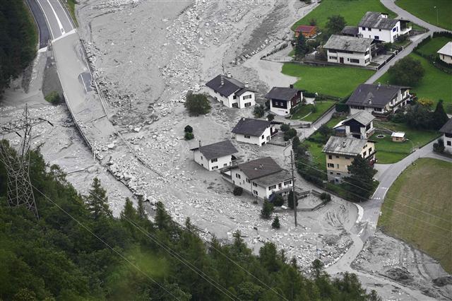 <YONHAP PHOTO-0293> A general view taken on August 24, 2017 shows houses covered by stones after a landslide struck during the night of August 23 in the village of Bondo, Switzerland. As many as 14 people are feared missing after a massive landslide swept away a mountainside in the Swiss Alps, ripping apart buildings and forcing the evacuation of a village, police said on August 24. The landslide, which struck on August 23, sent mud, rocks and dirt flooding down the Piz Cengalo mountain into the outskirts of the village of Bondo, near the Italian border. About 100 people were evacuated, some airlifted out by helicopters. / AFP PHOTO / MIGUEL MEDINA/2017-08-25 01:40:01/ <저작권자 ⓒ 1980-2017 ㈜연합뉴스. 무단 전재 재배포 금지.>