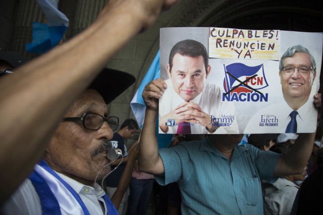 <YONHAP PHOTO-1390> A demonstrator holds images of Guatemala's President Jimmy Morales, left, and his Vice President Jafeth Cabrera that reads in English: "Guilty! Resign now!" during a protest outside the National Palace of Culture in Guatemala City, Sunday, Aug. 27, 2017, as Morales stands firm on his decision to expel the head of a U.N. anti-corruption commission. On Friday, the U.N. commission announced they were seeking the removal of Morales' immunity to pursue an investigation into campaign finance violations. (AP Photo/Luis Soto)/2017-08-28 07:31:21/ <저작권자 ⓒ 1980-2017 ㈜연합뉴스. 무단 전재 재배포 금지.>
<YONHAP PHOTO-1390> A demonstrator holds images of Guatemala's President Jimmy Morales, left, and his Vice President Jafeth Cabrera that reads in English: "Guilty! Resign now!" during a protest outside the National Palace of Culture in Guatemala City, Sunday, Aug. 27, 2017, as Morales stands firm on his decision to expel the head of a U.N. anti-corruption commission. On Friday, the U.N. commission announced they were seeking the removal of Morales' immunity to pursue an investigation into campaign finance violations. (AP Photo/Luis Soto)/2017-08-28 07:31:21/ <저작권자 ⓒ 1980-2017 ㈜연합뉴스. 무단 전재 재배포 금지.>