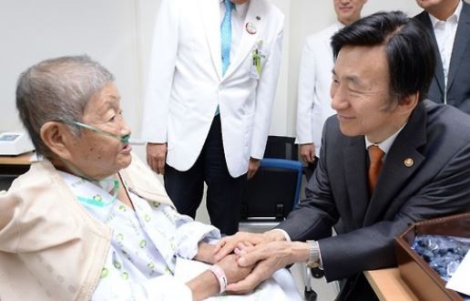 This photo, provided by the foreign ministry on Sept. 12, 2016, shows former Foreign Minister Yun Byung-se (R) visiting Ha Sang-sook, a South Korean victim of Japan's wartime sexual slavery, at a hospital in Seoul. (Yonhap)