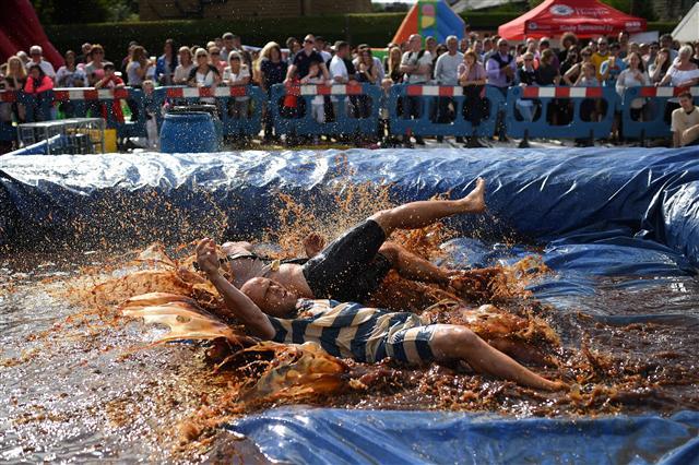 <YONHAP PHOTO-0088> Competitors take part in the 10th annual World Gravy Wrestling Championships held at the Rose 'n' Bowl Pub near Bacup, north west England on August 28, 2017. Contestants participate in fancy dress and wrestle in a pool of Lancashire Gravy for two minutes whilst being scored for a variety of wrestling moves. / AFP PHOTO / Oli SCARFF/2017-08-29 00:28:32/ <저작권자 ⓒ 1980-2017 ㈜연합뉴스. 무단 전재 재배포 금지.>