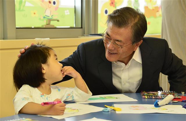 정부가 내년 사상 최대 규모의 복지ㆍ교육 예산 투입을 통해 사람 중심의 소득주도 성장에 본격 시동을 건다는 방침이다. 사진은 문재인 대통령이 지난 9일 건강보험 보장성 강화 대책 발표에 맞춰 방문한 서울의 한 병원에서 환아를 위로하며 교감하고 있다.  [연합뉴스]
