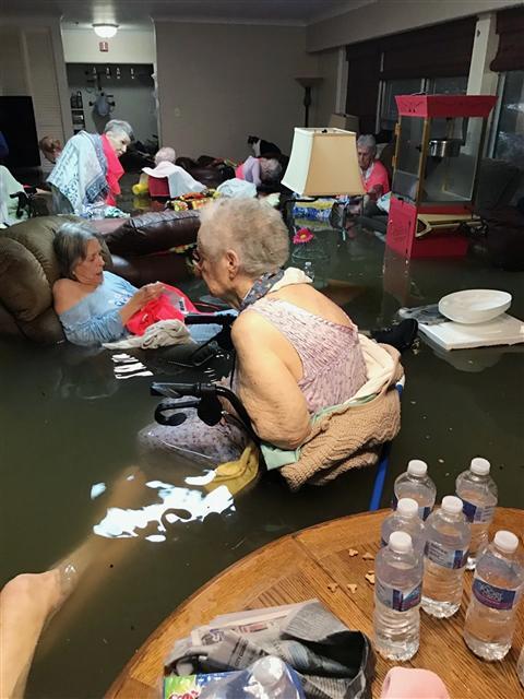 <YONHAP PHOTO-0909> In this Sunday, Aug. 27, 2017, photo provided by Trudy Lampson, residents of the La Vita Bella nursing home in Dickinson, Texas, sit in waist-deep flood waters caused by Hurricane Harvey. Authorities said all the residents were safely evacuated from the facility. (Trudy Lampson via AP)/2017-08-29 06:07:55/ <저작권자 ⓒ 1980-2017 ㈜연합뉴스. 무단 전재 재배포 금지.>