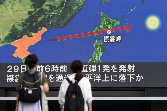Pedestrians watch the news on a huge screen displaying a map of Japan and the Korean Peninsula, in Tokyo on Tuesday following a North Korean missile test that passed over Japan. (AFP-Yonhap)