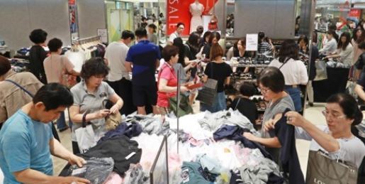 In this file photo taken on July 2, 2017, shoppers go through discount items at Lotte Department Store in downtown Seoul. (Yonhap)