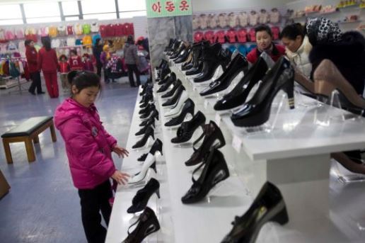 A girl looks at shoes for women at the Kwangbok Area shopping center in Pyongyang, North Korea. (AP-Yonhap)