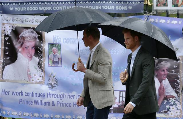 <YONHAP PHOTO-0416> TOPSHOT - Britain's Prince William, Duke of Cambridge (L) and Britain's Prince Harry look at tributes left by members of the public at one of the entrances of Kensington Palace to mark the coming 20th anniversary of the death of Diana, Princess of Wales, in London on August 30, 2017. Princes William and Harry prepared to pay tribute to their late mother Princess Diana on Wednesday for the 20th anniversary of her death as wellwishers left candles and flowers outside the gates of her former London residence. The Princes visited the Sunken Garden in the grounds of Kensington Palace, which this year has been transformed into a White Garden, dedicated to their late mother, Britain's Diana, Princess of Wales. / AFP PHOTO / Daniel LEAL-OLIVAS/2017-08-31 01:19:31/ <저작권자 ⓒ 1980-2017 ㈜연합뉴스. 무단 전재 재배포 금지.>