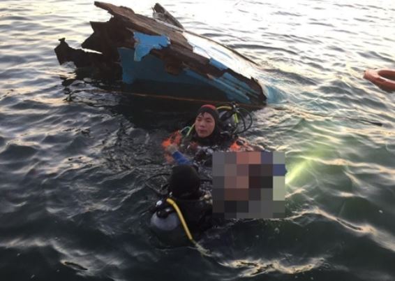 A rescuer reaches a submerged fishing boat in waters off Pohang on South Korea's southeastern coast on Aug. 31, 2017, after it collided with a barge in this photo released by the Coast Guard. (Yonhap)