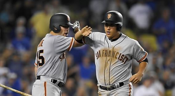 In this Associated Press photo taken on July 28, 2017, Hwang Jae-gyun of the San Francisco Giants (R) is congratulated by Matt Moore after scoring a run against the Los Angeles Dodgers in the teams' Major League Baseball game at Dodger Stadium in Los Angeles. (Yonhap)