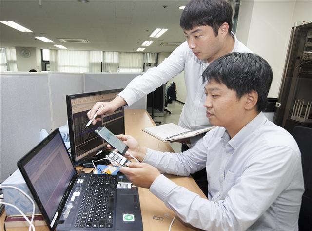 SK텔레콤 직원들이 ‘실시간 검출 시스템’을 활용해 스마트폰 복제 여부를 실시간으로 확인하고 있다.  [제공=SK텔레콤]