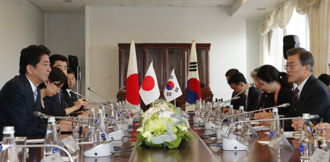 South Korean President Moon Jae-in (right) and Japanese Prime Minister Shinzo Abe hold a summit meeting in Vladivostok, Russia on Thursday. (Yonhap)