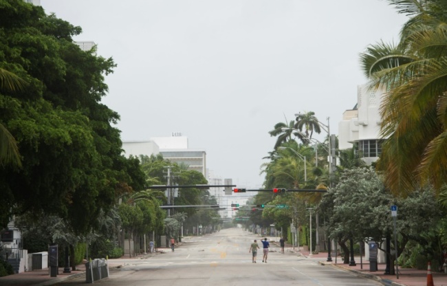 People walk down a deserted street in Miami Beach, Florida, as the outer bands of Hurricane Irma arrive. The storm weakened slightly to a Category 4 after making landfall hours earlier in Cuba with maximum-strength Category 5 winds