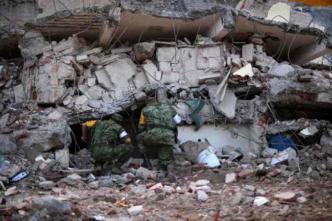 Soldiers with specially trained dogs search for survivors amid the ruins of buildings knocked down Thursday night by a 8.1-magnitude quake, in Juchitan de Zaragoza, Mexico, on September 9, 2017. Police, soldiers and emergency workers raced to rescue survivors from the ruins of Mexico's most powerful earthquake in a century, which killed at least 61 people, as storm Katia menaced the country's eastern coast Saturday with heavy rains. (AFP-Yonhap)