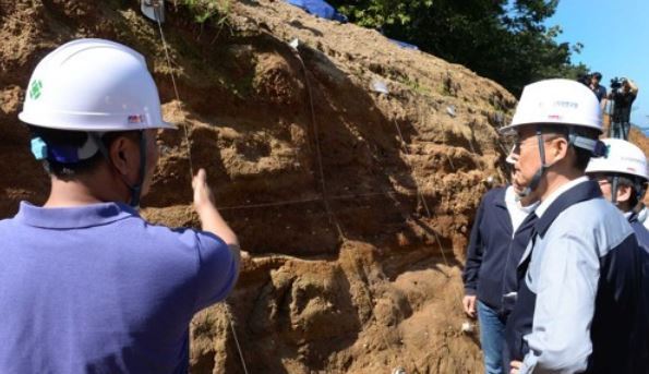 Paik Un-gyu, the chief of the Ministry of Trade, Industry and Energy, visits a fault line located near the epicenter of a 5.8 magnitude earthquake that hit Gyeongju in 2016 to mark the first anniversary of the nation's largest recorded quake on Sept. 12, 2017, in this photo provided by the ministry. (Yonhap)