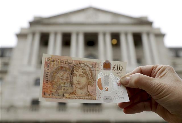 <YONHAP PHOTO-4654> One of the new British 10 pound notes is posed for photographs outside the Bank of England in the City of London, Thursday, Sept. 14, 2017. The new polymer note, released for circulation on Thursday, features the renowned novelist Jane Austen and is the first UK banknote with a tactile feature to support blind and partially sighted users. (AP Photo/Matt Dunham)/2017-09-14 17:53:44/ <저작권자 ⓒ 1980-2017 ㈜연합뉴스. 무단 전재 재배포 금지.>