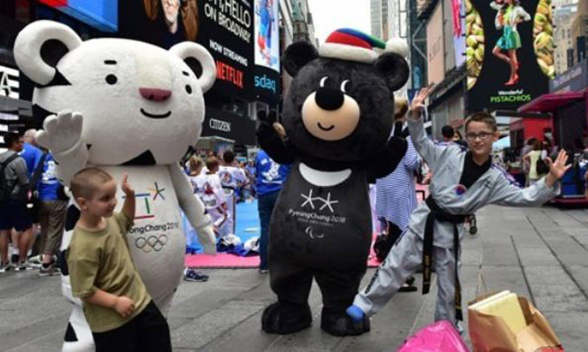 Soohorang (L) and Bandabi, mascots of the 2018 PyeongChang Winter Olympics, pose with American children during an event to promote the games at Times Square in Manhattan, New York, on June 23, 2017. The event was organized by the Korea Tourism Organization, which also provided the photo. (Yonhap)