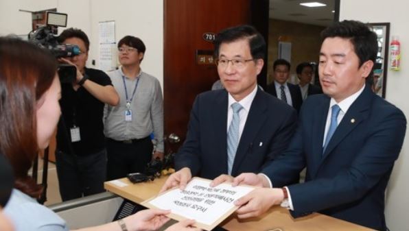 Two lawmakers of the ruling Democratic Party submit to the legislature a motion calling for a parliamentary probe into alleged attempts by past governments to meddle in local broadcasters at the National Assembly in Seoul on Sept. 15, 2017. (Yonhap)