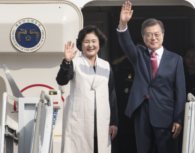 President Moon Jae-in and First Lady Kim Jung-sook wave on their way to New York on Monday. Yonhap