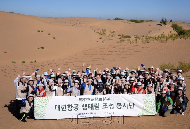 중국 네이멍구 쿠부치 사막에 조성된 ‘대한항공 녹색 생태원’에서 대한항공 직원들이 19일(현지시간) 희망의 나무심기에 앞서 기념촬영을 하고 있다.［중국 쿠부치=이길동 기자/gdlee@heraldcorp.com］