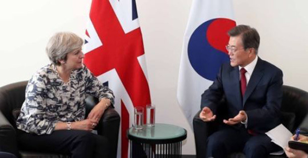 South Korean President Moon Jae-in (R) and British Prime Minister Theresa May talk in their bilateral summit held on the sidelines of the U.N. General Assembly in New York on Sept. 19, 2017. (Yonhap)