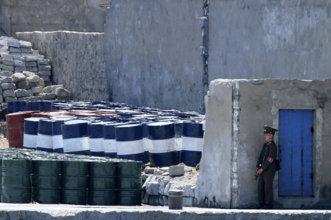 A North Korean solder stands guard near barrels stacked up near the river bank of the North Korean town of Sinuiju, opposite the Chinese border city of Dandong. China announced Saturday, Sept. 23, 2017 it will limit oil supplies to North Korea under UN sanctions starting Oct. 1, 2017, stepping up pressure on Pyongyang over its pursuit of nuclear and missile technology. (AP)