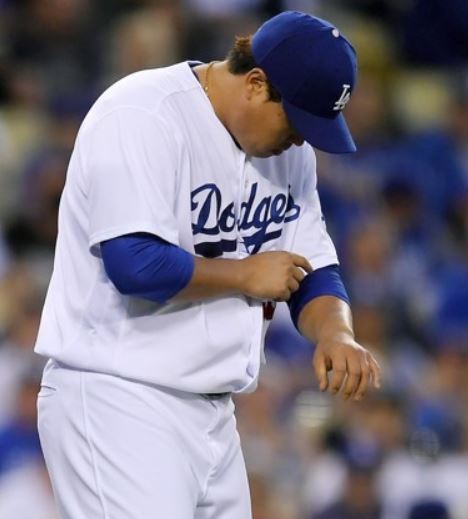 In this Associated Press photo, Ryu Hyun-jin of the Los Angeles Dodgers looks at his left arm after it was hit by a line drive off the bat of Joe Panik of the San Francisco Giants in the top of the third inning in the teams' regular season game at Dodger Stadium in Los Angeles on Sept. 23, 2017. (Yonhap)