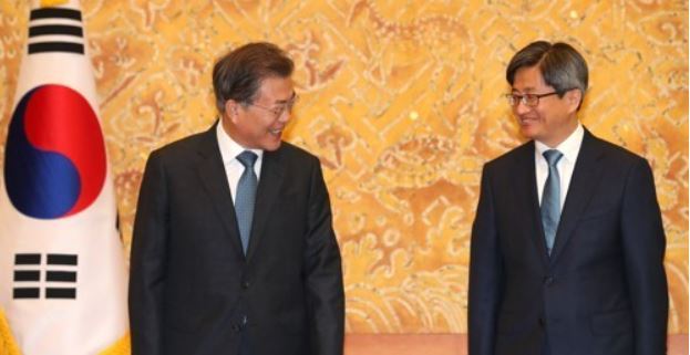 President Moon Jae-in (L) speaks with new Supreme Court Chief Justice Kim Meong-su after appointing him in a ceremony held at the presidential office Cheong Wa Dae on Sept. 25, 2017. (Yonhap)